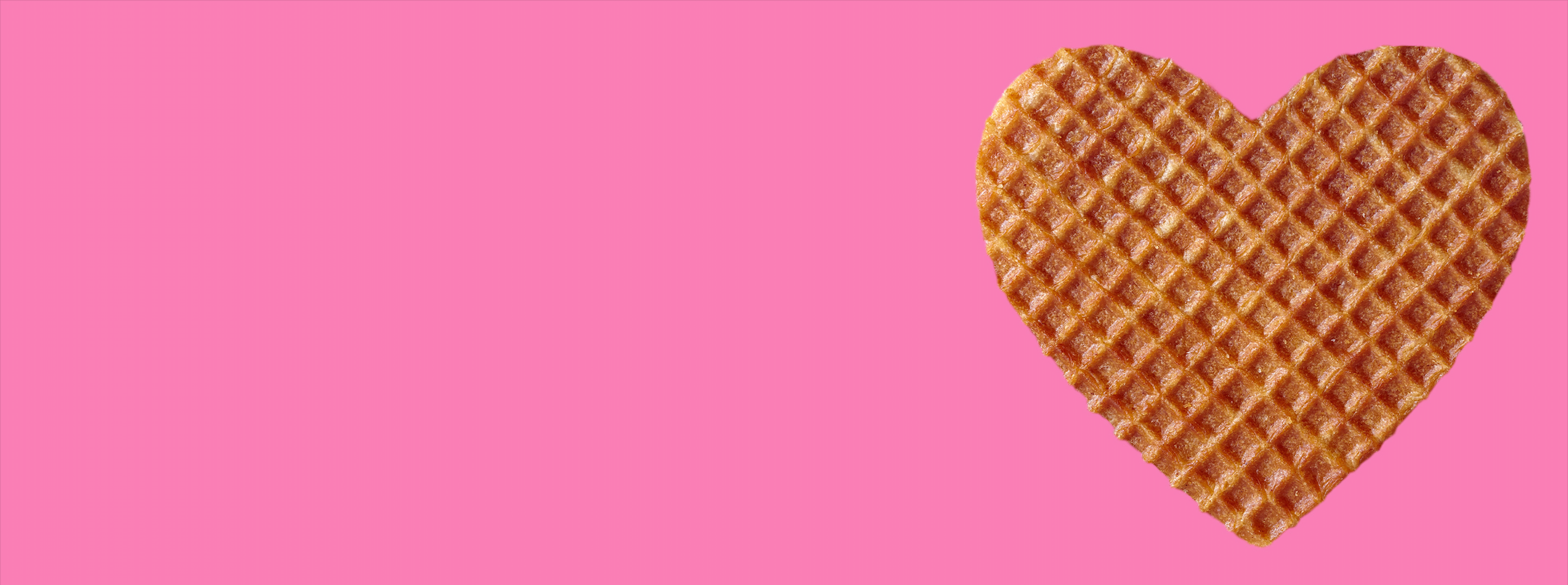 Heart shaped stroopwafel over pink background for Valentine's Day